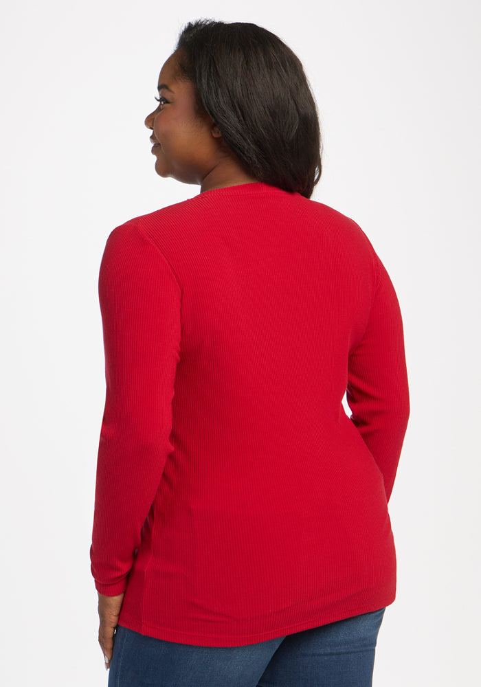 Woman in Woolx Hadley Ribbed Crew - Maraschino Cherry and jeans, smiling while facing away from the camera.