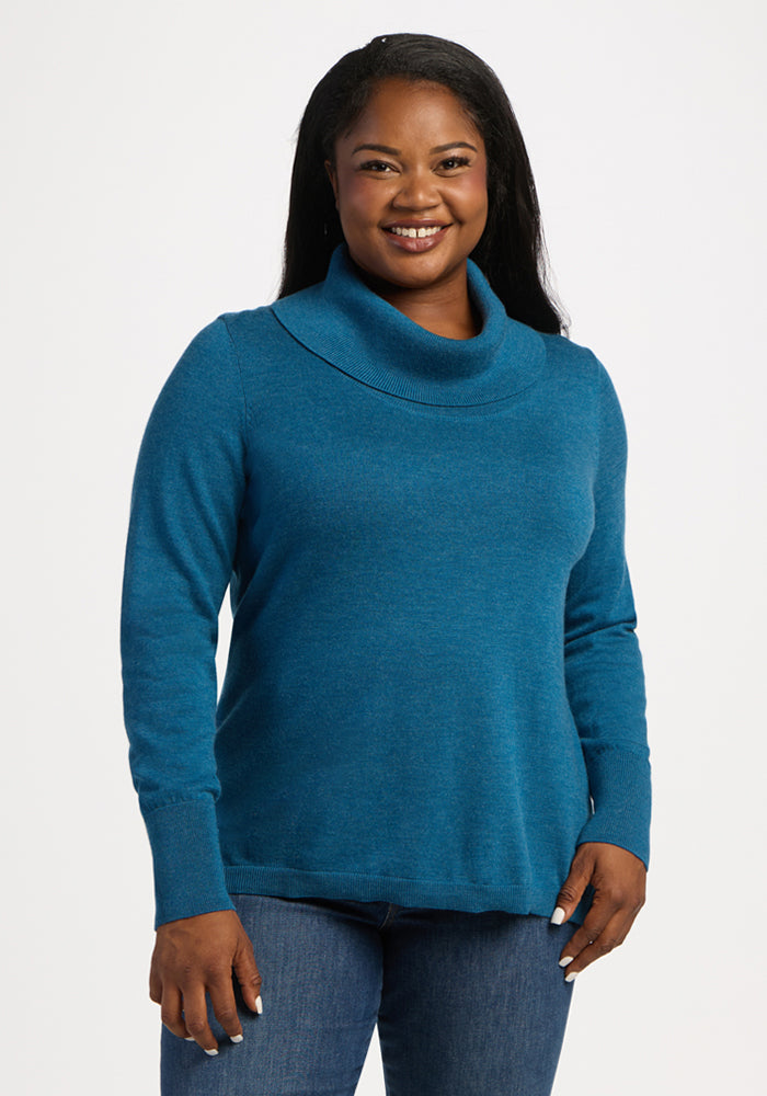 Smiling woman in Woolx Josie Cowl Neck Sweater—Blue Pine—paired with jeans against a plain white background. 