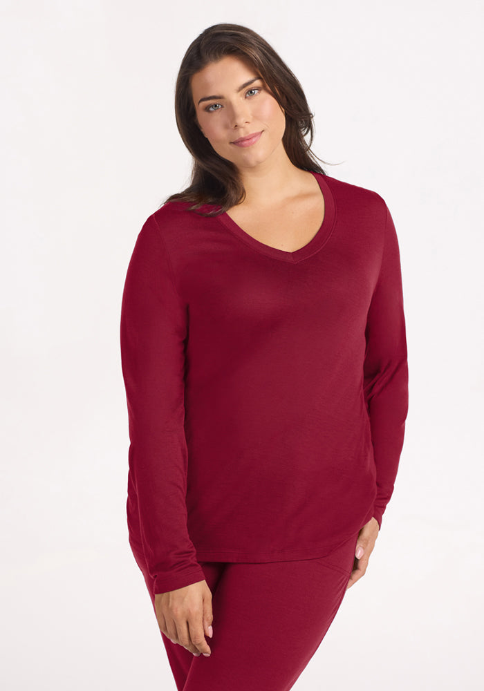A person wearing a long-sleeved, beet-red Woolx Lily V Neck Lounge Top. 