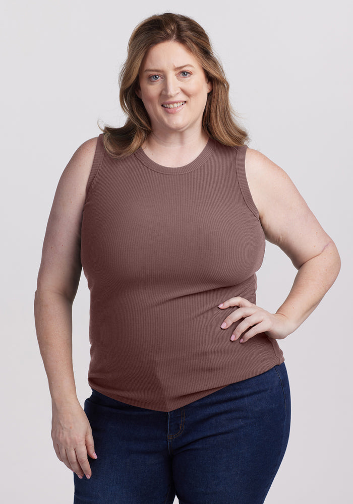 Smiling woman wears the Woolx Raegan Ribbed Tank Top in Peppercorn and dark jeans against a plain background. 