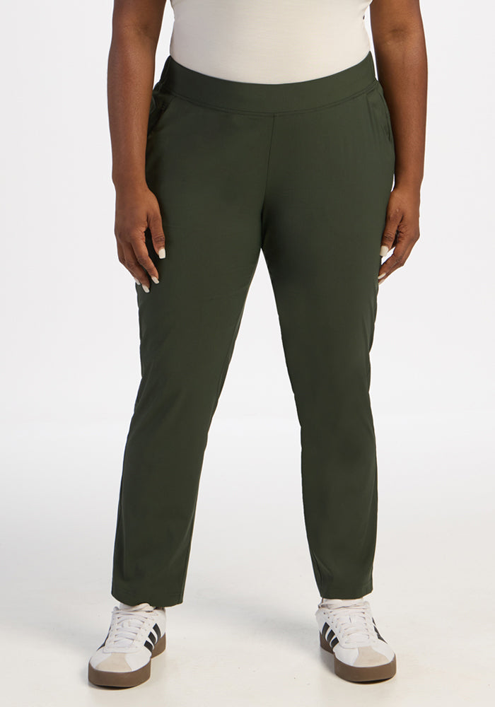 Person wears Woolx Nicole Ankle Pants in Duffel Bag, a white top, and sneakers against a plain white background. 