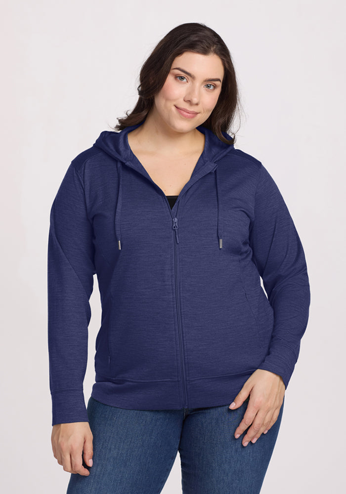 Woman in Woolx Ryann Hoodie - Twilight Storm and jeans, smiling against a plain light background. 