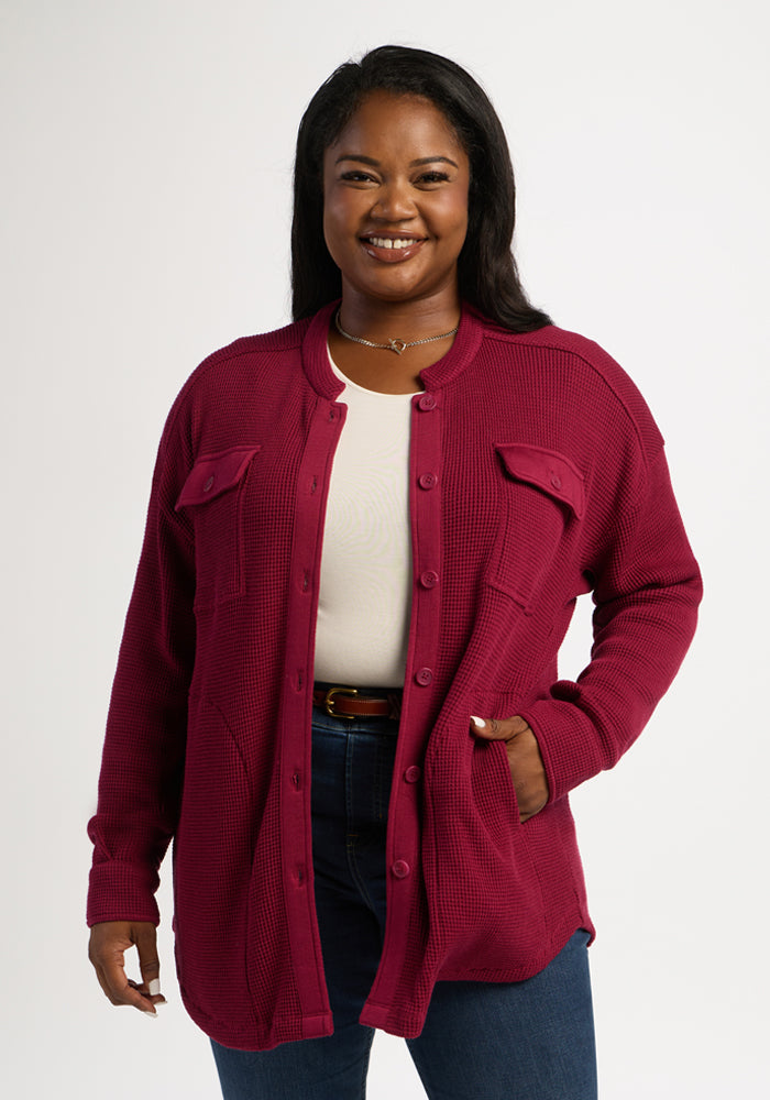 Smiling woman in Woolx Oaklynn Waffle Shacket - Beet Red, white top, and jeans, one hand in her pocket. 