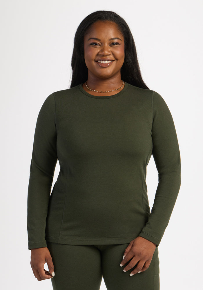 Woman smiling in Woolx Elsa Long Sleeve - Duffel Bag, standing against a plain white background.