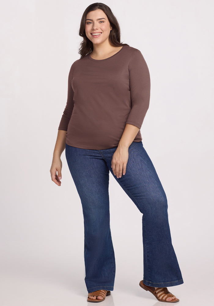 Woman wears the Woolx Jenny 3/4 Sleeve Crew Neck in Peppercorn and blue flared jeans, smiling against a light background.