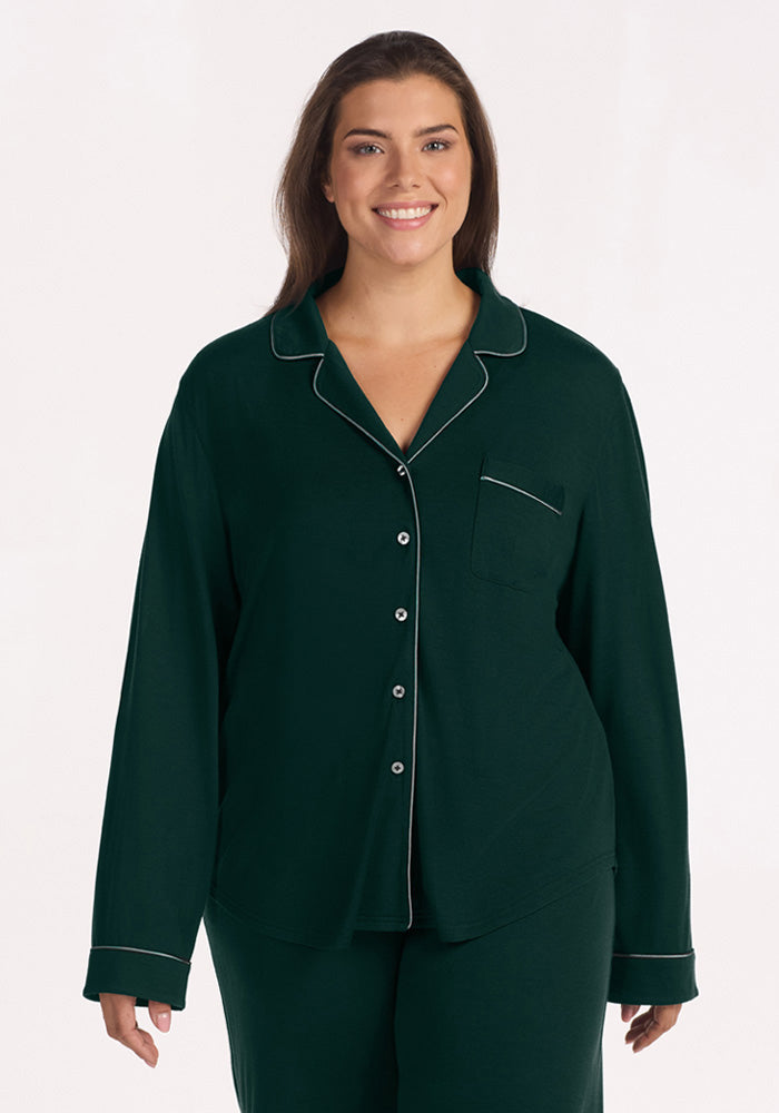 A smiling woman wearing a deep pine Harper FeatherTouch® Pajama Set top with light-colored piping.