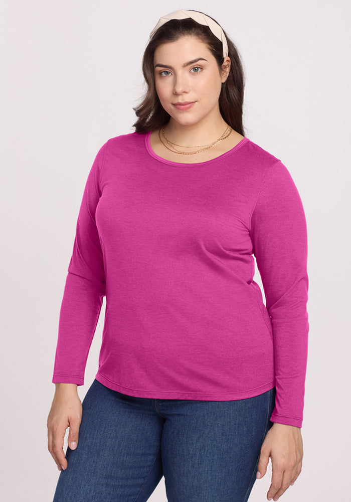 Woman wears the Woolx Remi Long Sleeve T-Shirt in Summer Sorbet with blue jeans against a plain light background. 