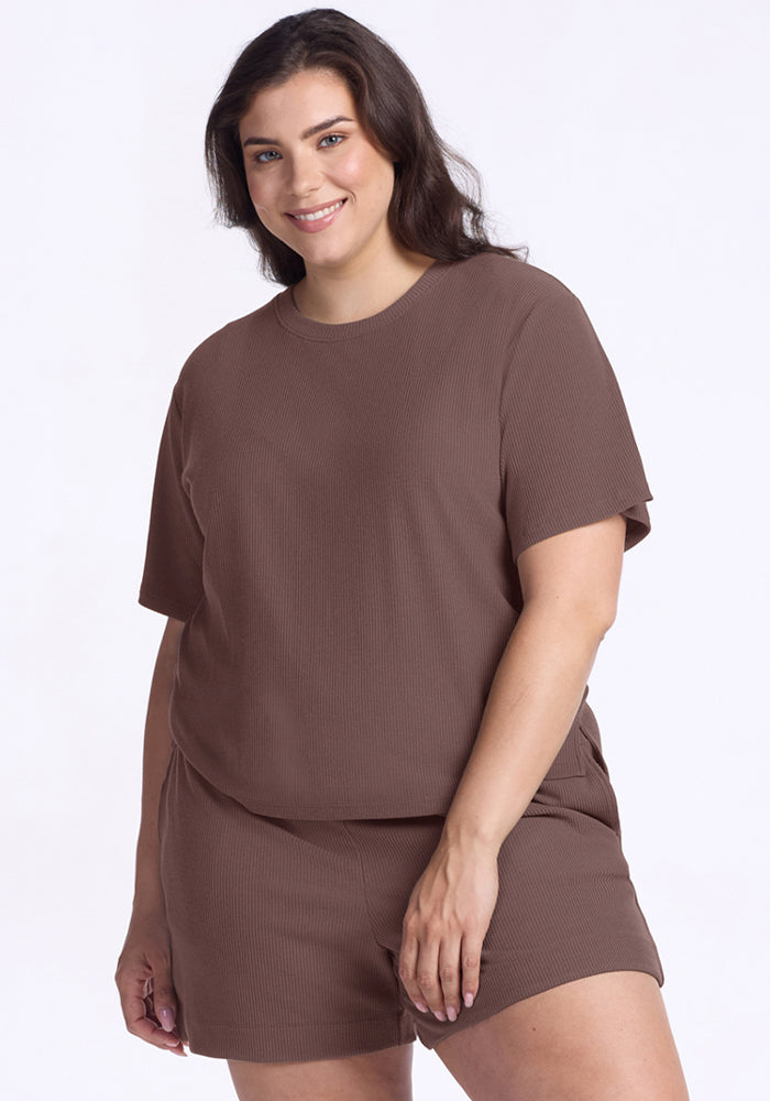 Woman smiles in Woolx Delia Ribbed Short Sleeve in Peppercorn and matching shorts against a plain light background. 