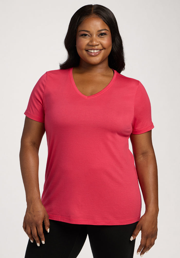 Woman smiling in the Woolx Junie V Neck - Berry Ice Pop tee and black pants, standing against a plain background. 