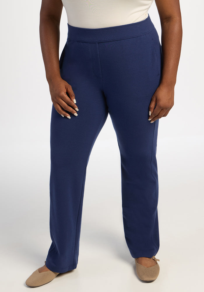 Model wears Woolx Emerson Straight Leg Pants in Ocean Cavern and beige flats, standing relaxed against a white background.