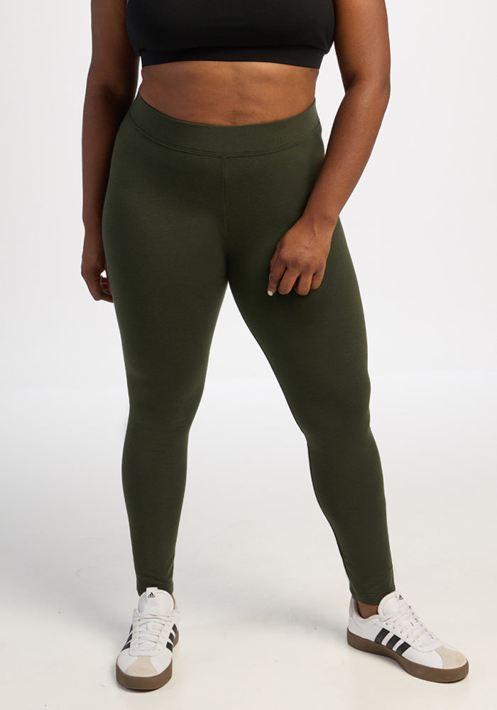 Person with a Woolx Stella Tall - Duffel Bag, black crop top, leggings, and white sneakers on a plain white background.