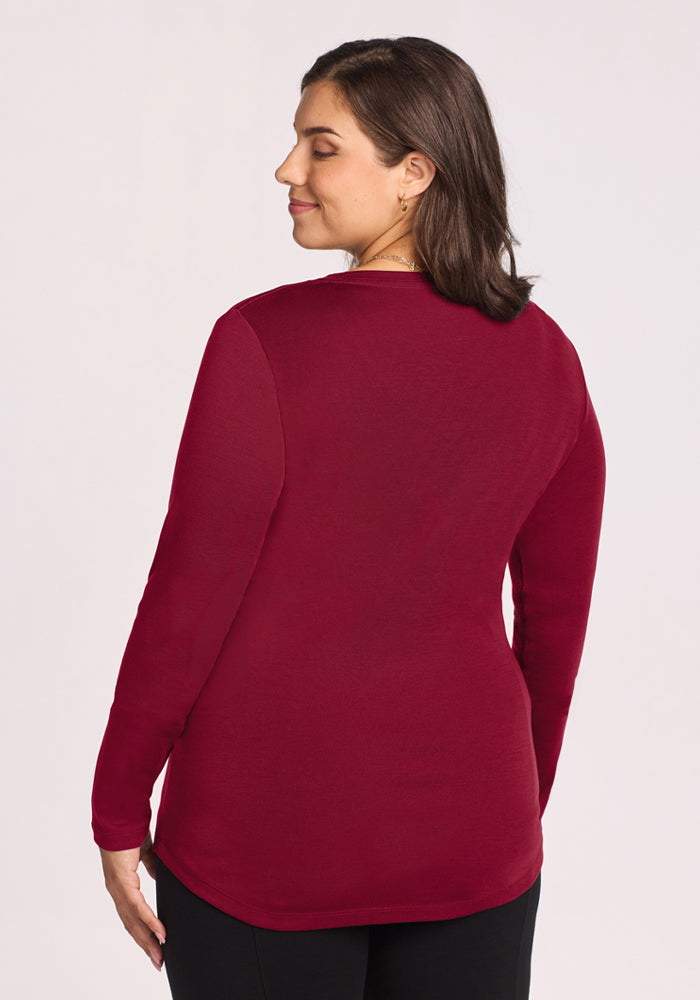 Woman with short brown hair in the Woolx Eva Tunic - Beet Red, facing away—an essential for your winter wardrobe.