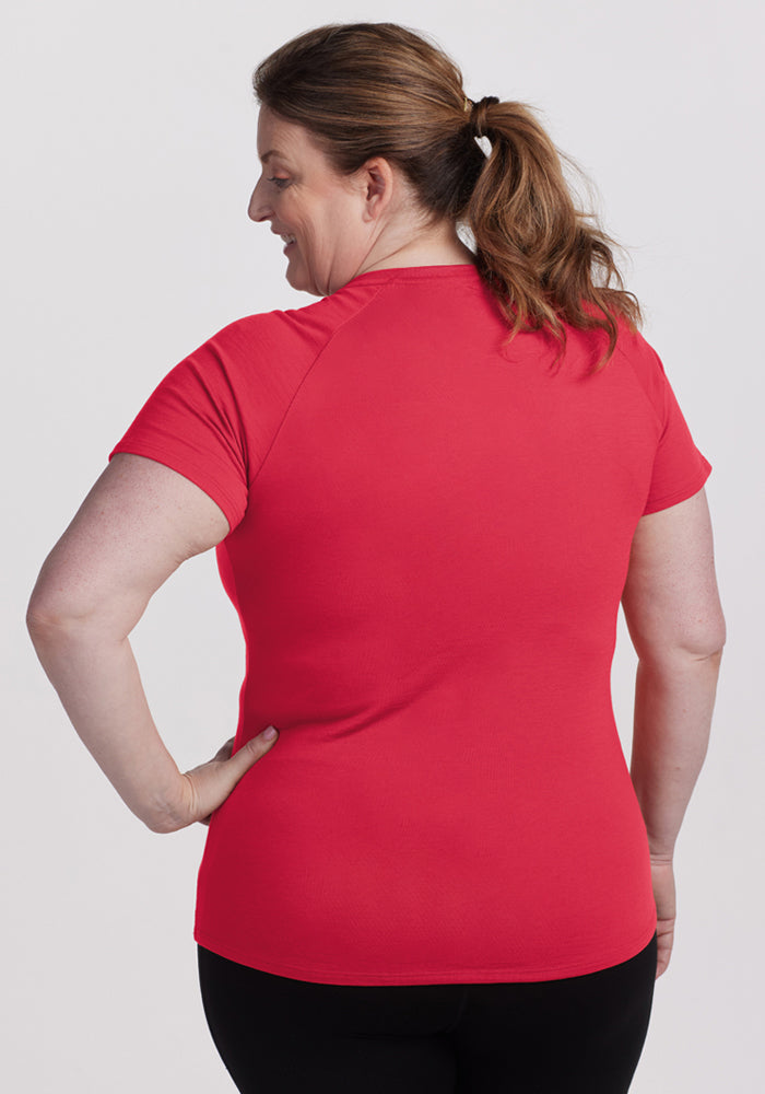 A woman with a ponytail faces away, wearing the Woolx Mia V Neck - Berry Ice Pop and black pants.