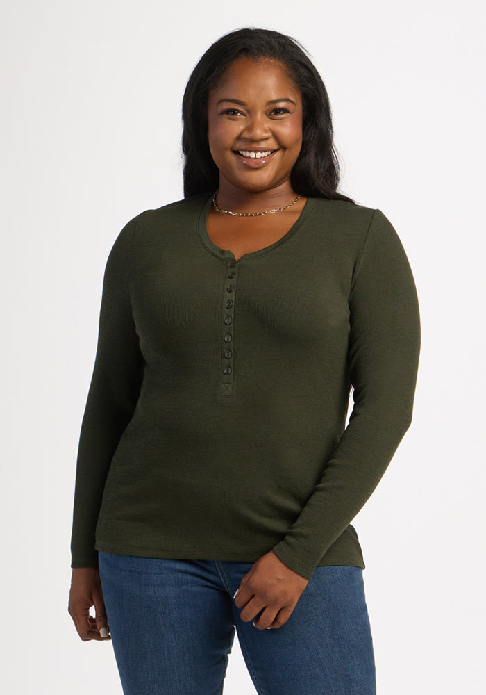 Woman in Woolx Reese Ribbed Henley - Duffel Bag and blue jeans, smiling against a plain background. 