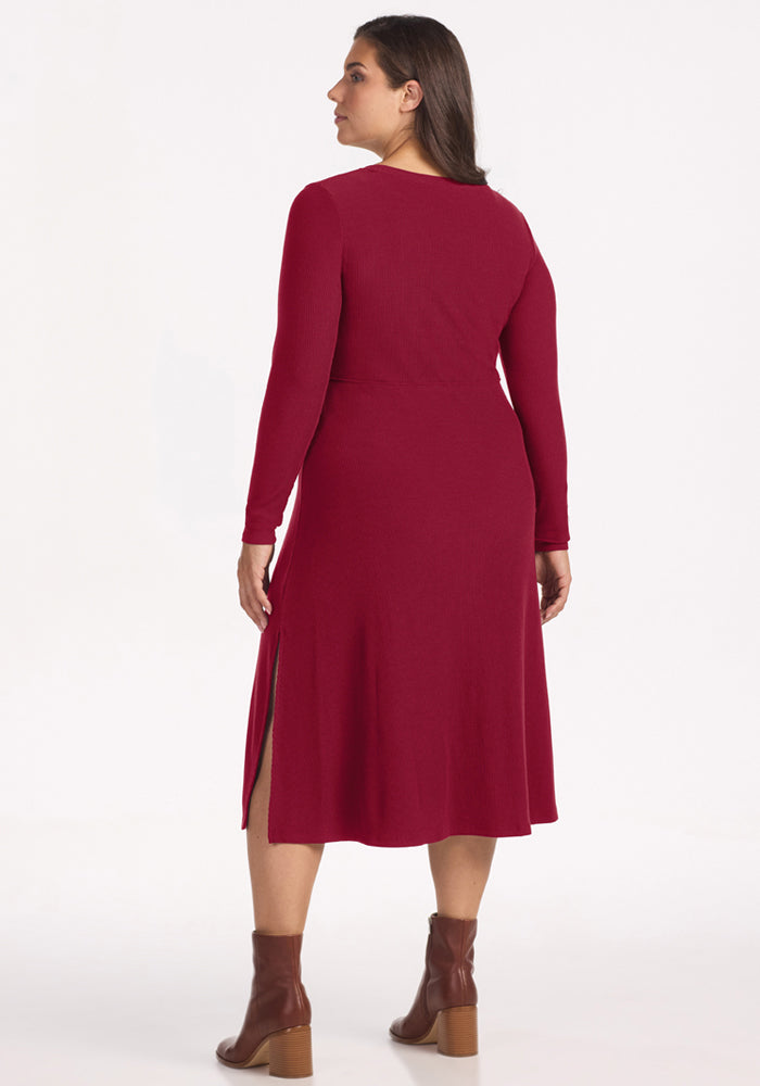 Woman in Woolx Caroline Ribbed Twirl Dress - Beet Red and brown boots, facing away from the camera.