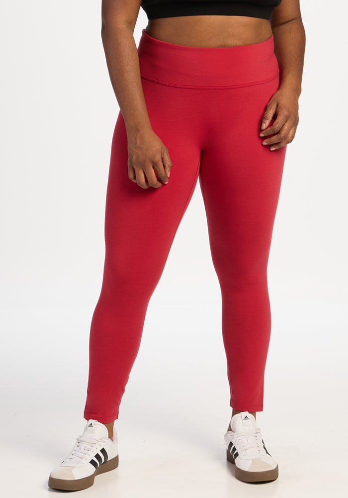 Person wearing Woolx Angela Leggings - Maraschino Cherry and white sneakers. 