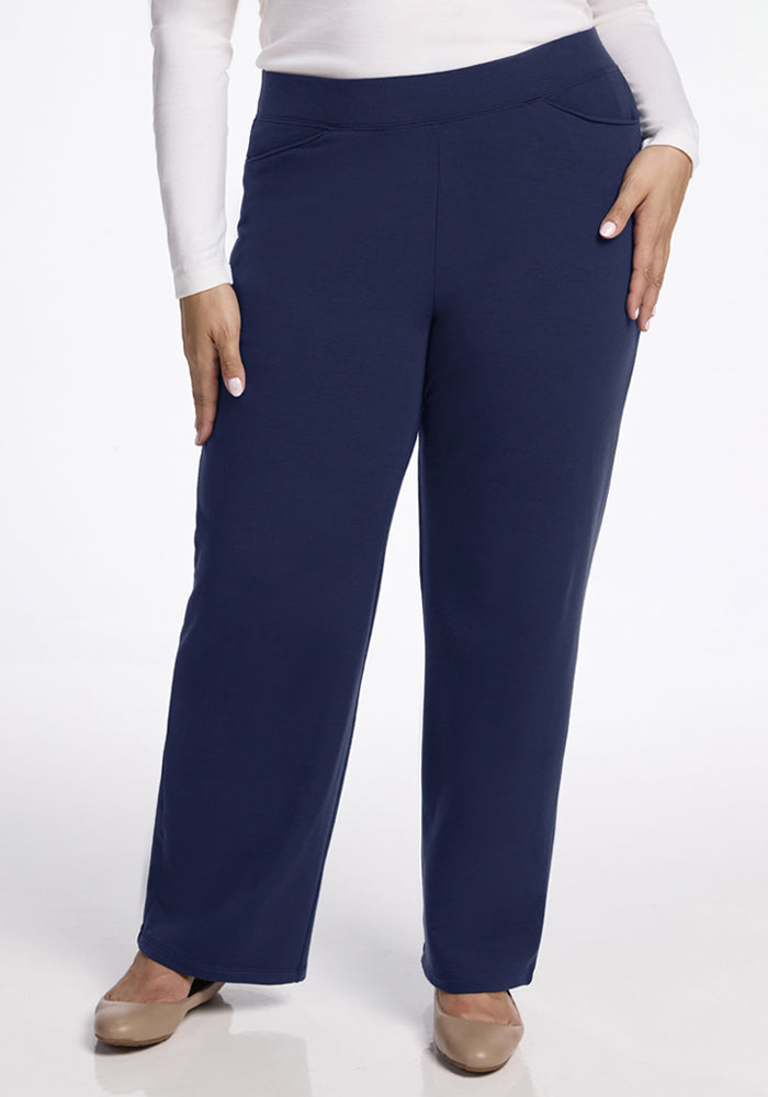 Person wears Woolx Ellie Wide Leg Pants - Ocean Cavern, white top, beige shoes, standing against a white background. 