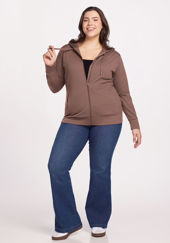 Woman wearing Woolx Ryann Hoodie in Toasted Almond with jeans and sneakers stands against a plain white background.