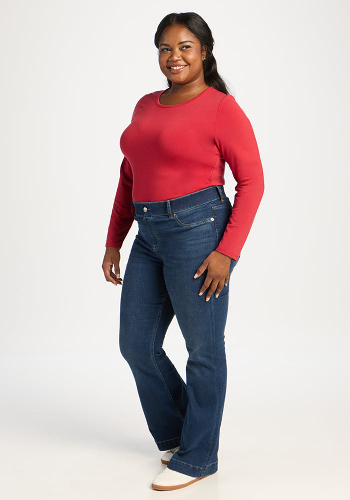 Woman in a Woolx Margot Bodysuit - Maraschino Cherry, smiling in studio, exuding buttery-soft comfort.