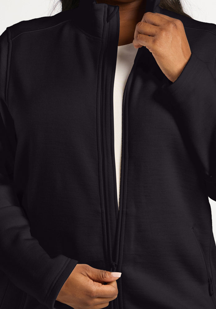 A person zips up a black, ultra-heavyweight merino wool Teddy Sweatshirt with a high collar.