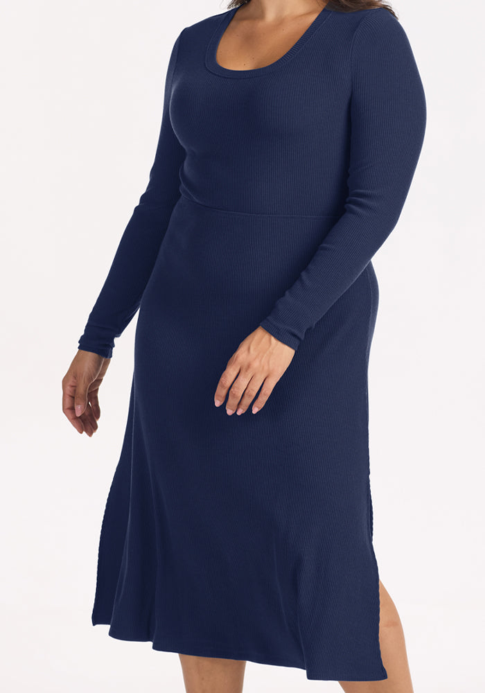 Woman in Woolx Caroline Ribbed Twirl Dress - Ocean Cavern: a navy, long-sleeve, travel-ready merino staple.