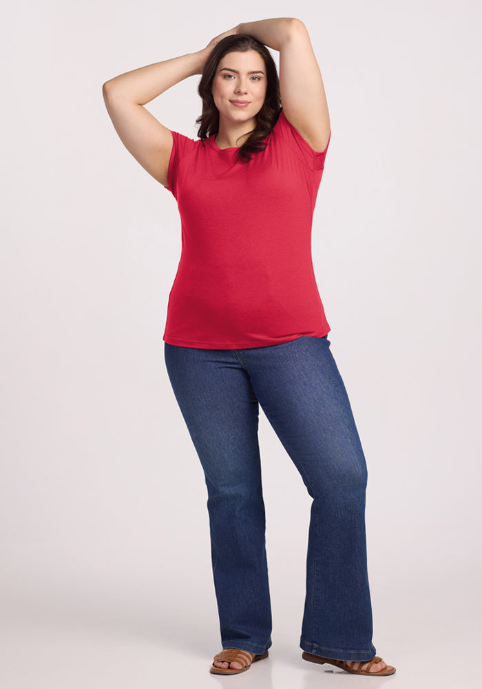 Woman wears Woolx Addie Crew Neck in Berry Ice Pop with blue jeans, standing confidently against a light background.