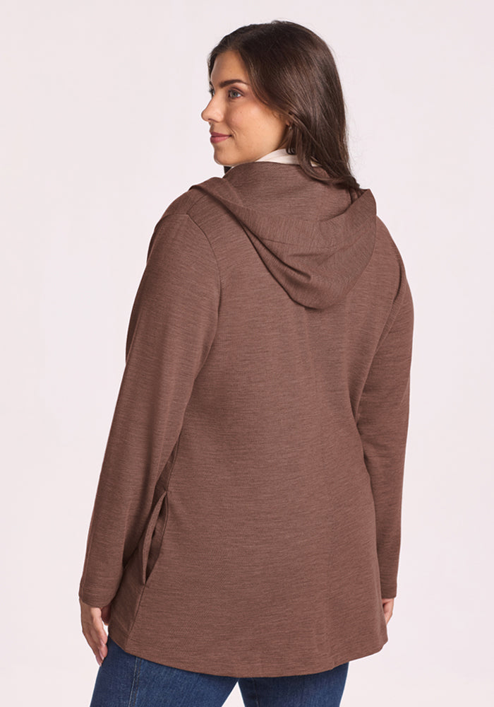 Woman in Woolx Edna Hooded Cardigan - Sable Heather and blue jeans glances back, set against a light background.