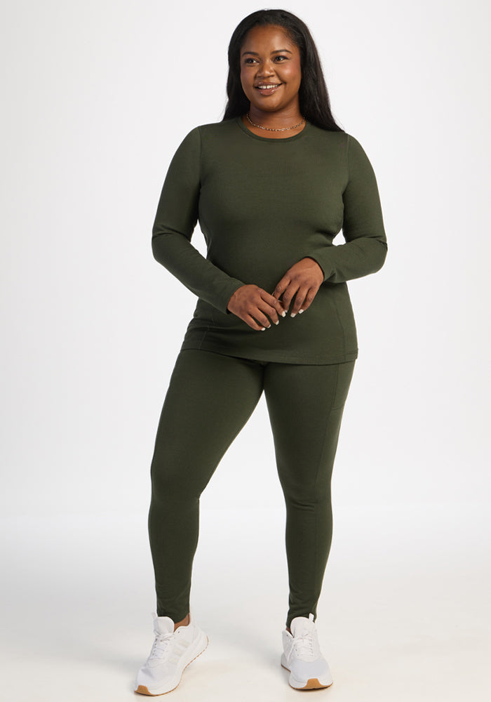 Woman smiling in a Woolx Elsa Long Sleeve - Duffel Bag shirt and pants set with white sneakers, on a white background.