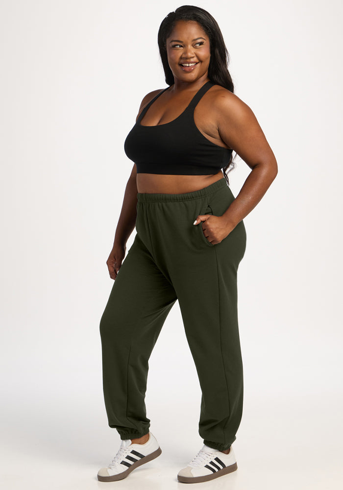 Smiling woman in Woolx Juliette Joggers - Duffel Bag, standing casually with one hand in her pocket.