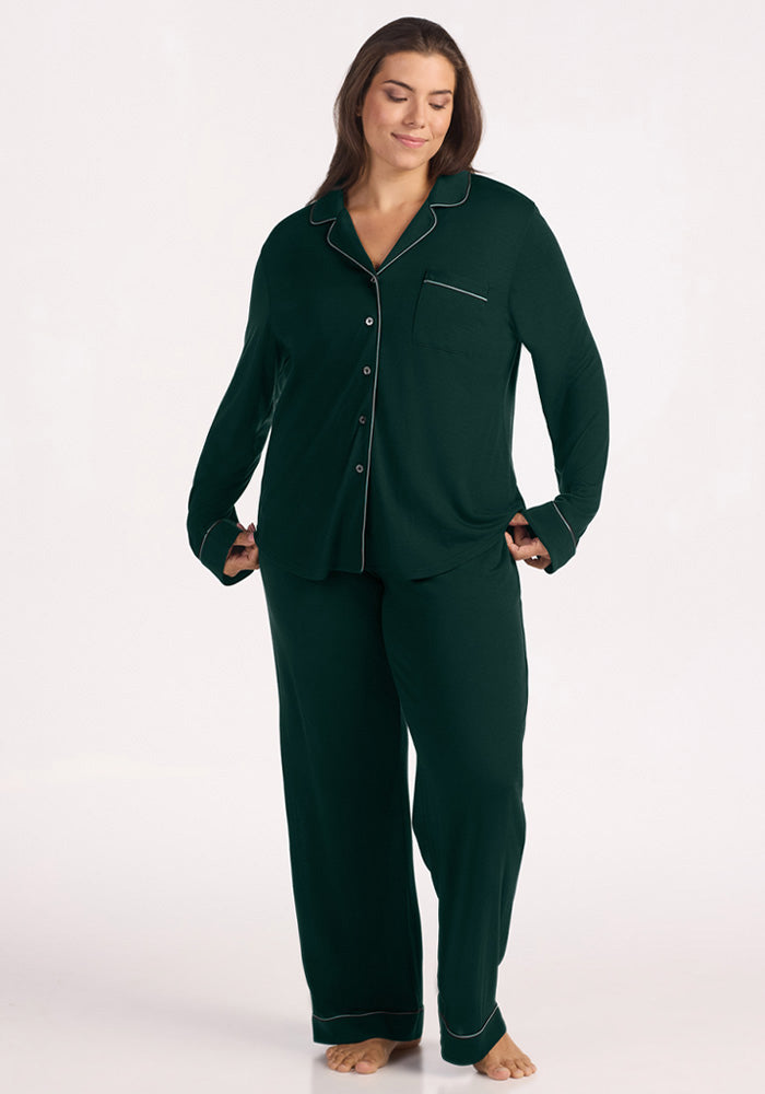 A woman wearing a Deep Pine Woolx Harper FeatherTouch® Pajama Set with light piping and wide-leg pants. 
