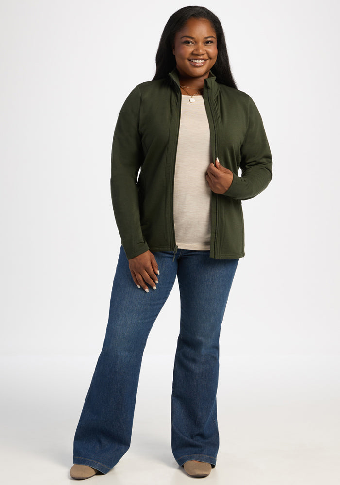 Woman smiling in Woolx Finley Zip Up Sweatshirt - Duffel Bag, beige top, jeans, and beige shoes on white background.
