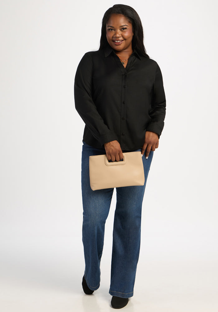 Woman in Woolx Lorelai Button Up - Black, blue jeans, holding beige clutch, stands against a white background.