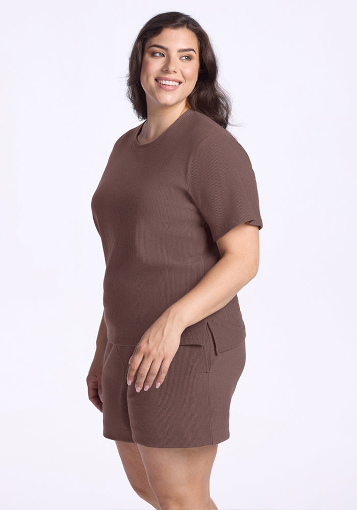 Woman smiling, wearing the Woolx Delia Ribbed Short Sleeve in Peppercorn, standing sideways against a plain background.