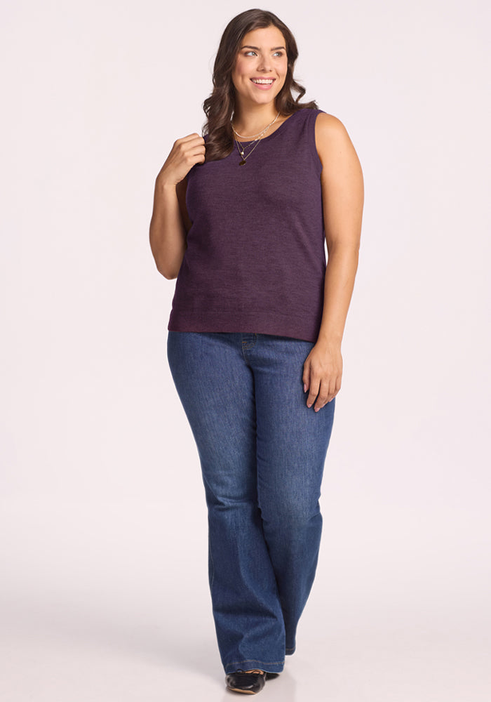 Woman smiling in Woolx Chessy Tank Top - Purple Iris and blue jeans against a plain light background.