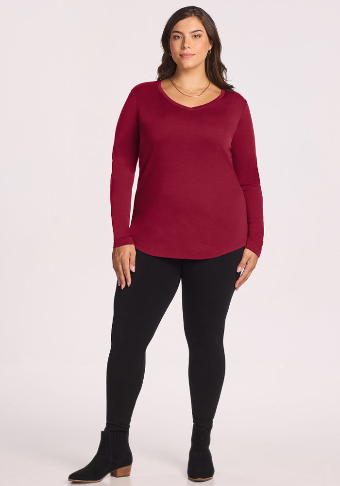 Woman in Woolx Eva Tunic - Beet Red, black leggings, and boots stands against a white background.