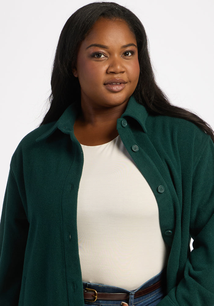 Woman with long dark hair in Woolx’s Jovie Shacket - Deep Pine over a white top, against a plain background.