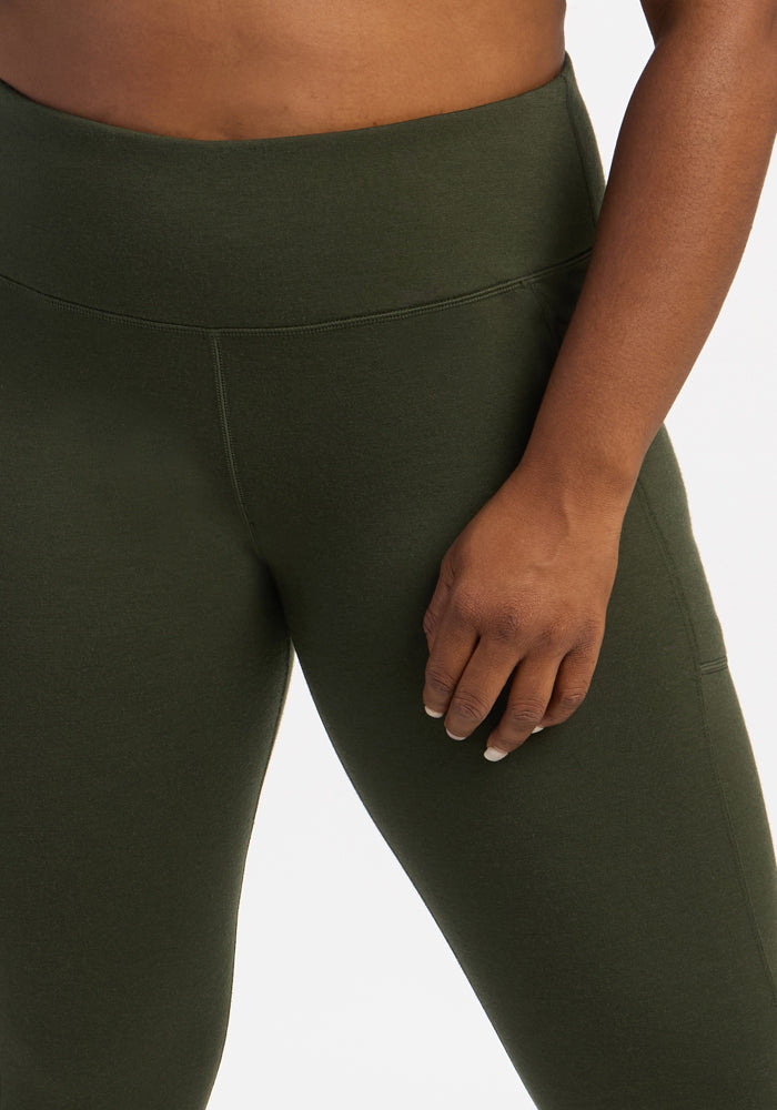 A person in Woolx Frost Leggings - Duffel Bag rests a hand on their thigh against a white background.