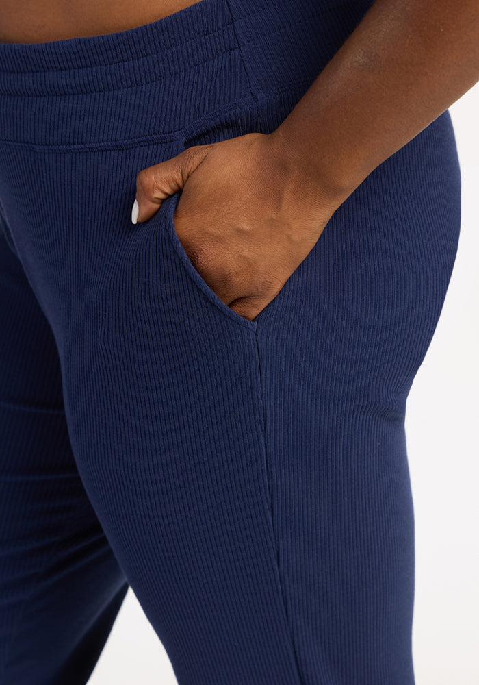 A model in Woolx Lennon Ribbed Joggers - Ocean Cavern, hand in pocket, shown waist to mid-thigh.