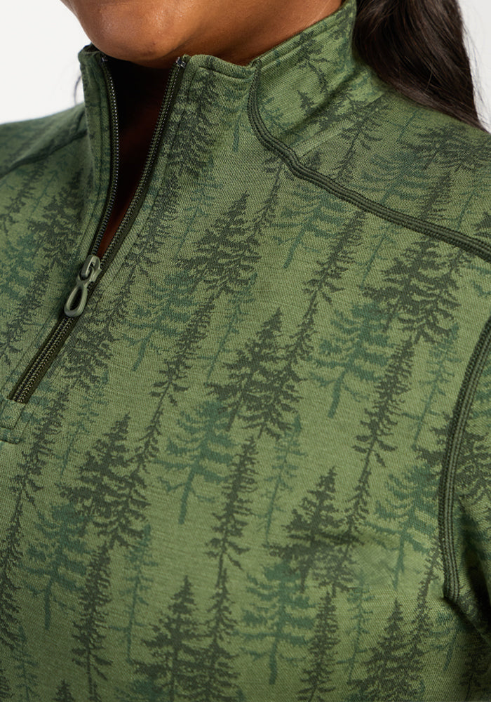 Close-up of a person wearing the Woolx Emi 1/4 Zip - Forest Friends Merino wool base layer with tree pattern.