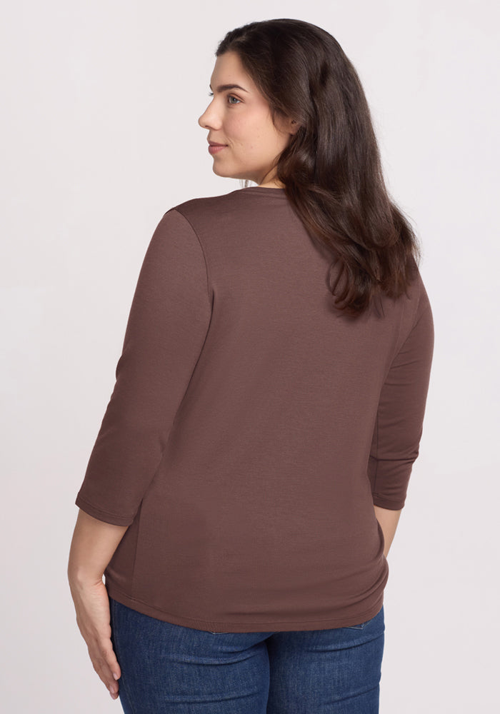 Woman with long brown hair wears the Woolx Jenny 3/4 Sleeve Crew Neck in Peppercorn, back turned, with blue jeans.