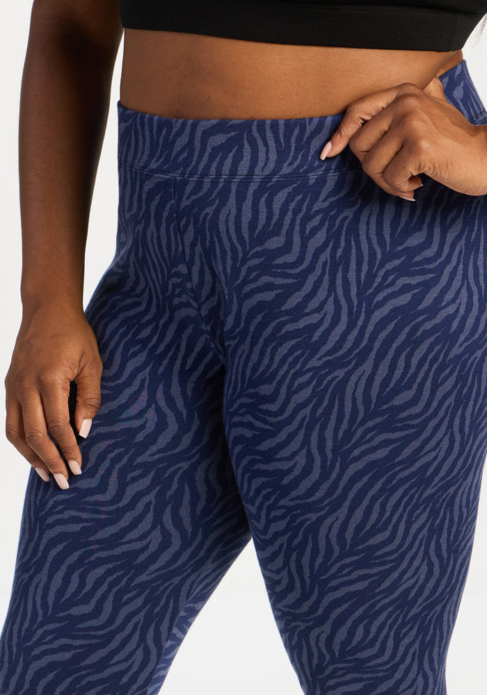 Model in Woolx Taylor Baselayer Leggings - Midnight Safari and a black crop top, hand resting on hip.