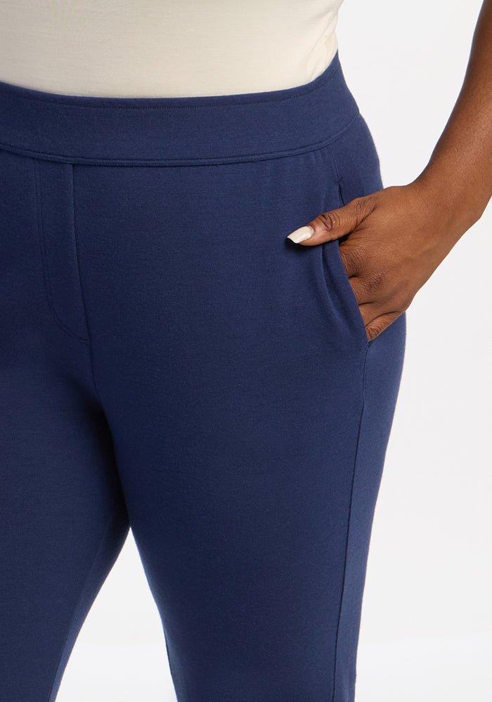 Person in Woolx Emerson Straight Leg Pants - Ocean Cavern and a white top, hand in pocket, against white backdrop.