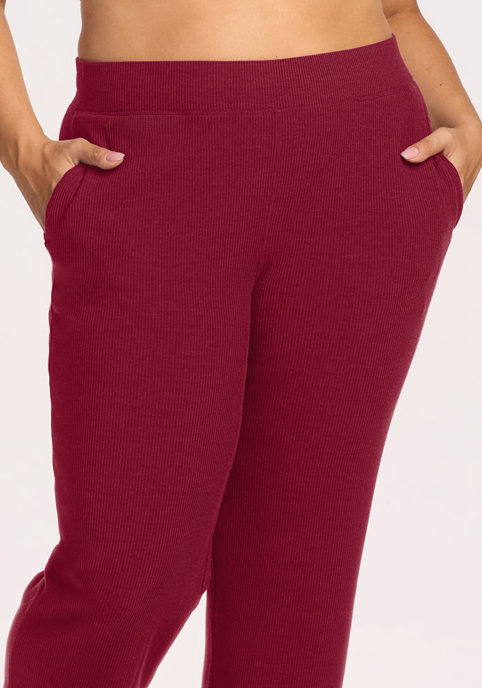 Model in Woolx Luca Ribbed Pants - Beet Red, waist to mid-thigh view, hands in pockets, white background.