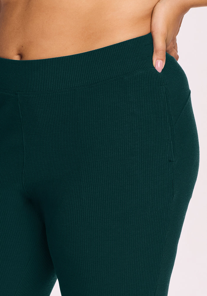 Close-up of a person wearing Woolx Luca Ribbed Pants in Deep Pine, one hand resting casually in a side pocket.