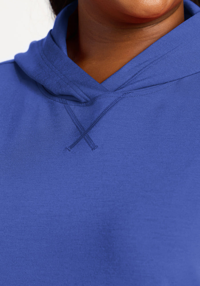 Close-up of person in Woolx Lizzy Hoodie - Royal Blue, highlighting buttery soft fabric and cozy neckline.