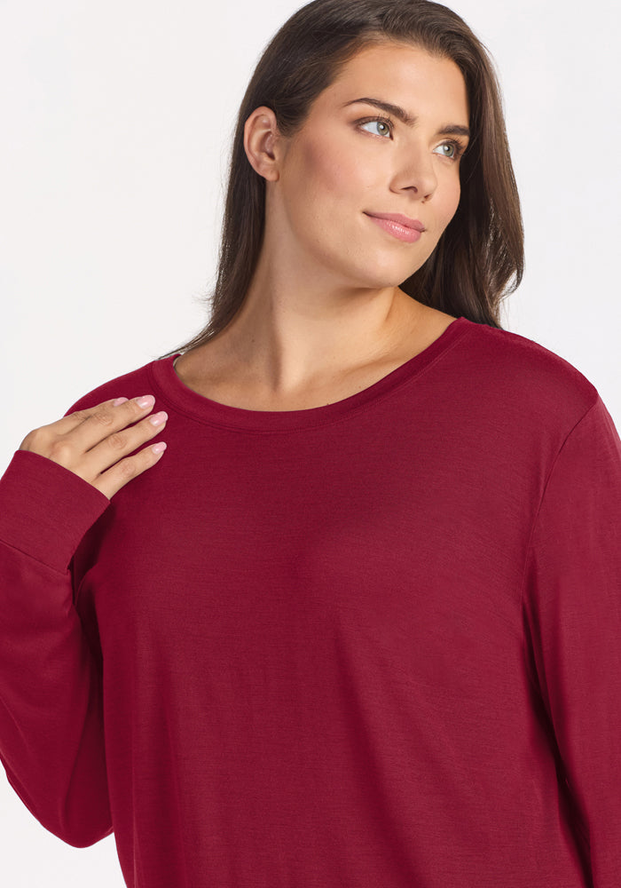 A woman wearing a beet red, wrinkle-resistant Merino wool Ashlie Lounge Top.