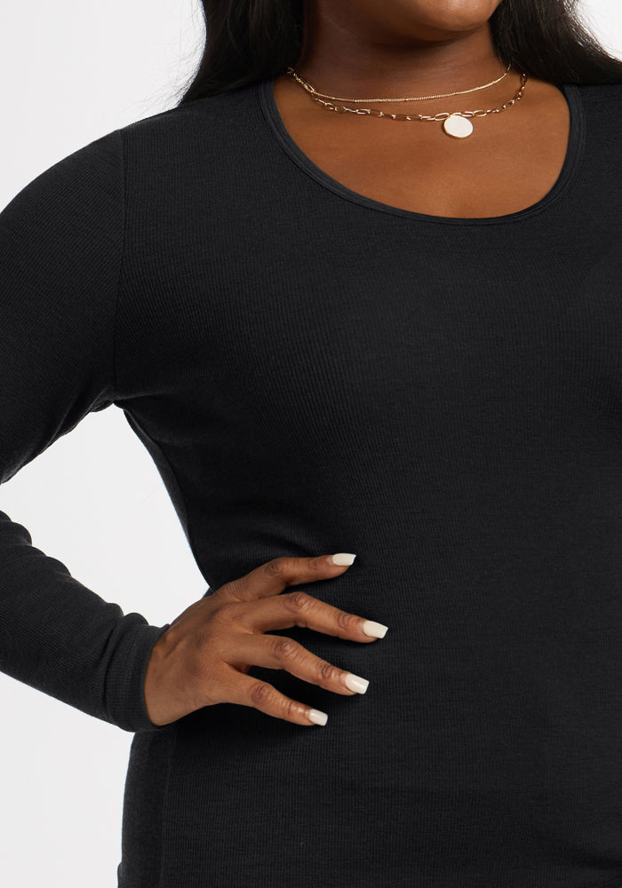Model wears the Woolx Katie Ribbed Long Sleeve in black, styled with layered necklaces and a pendant.