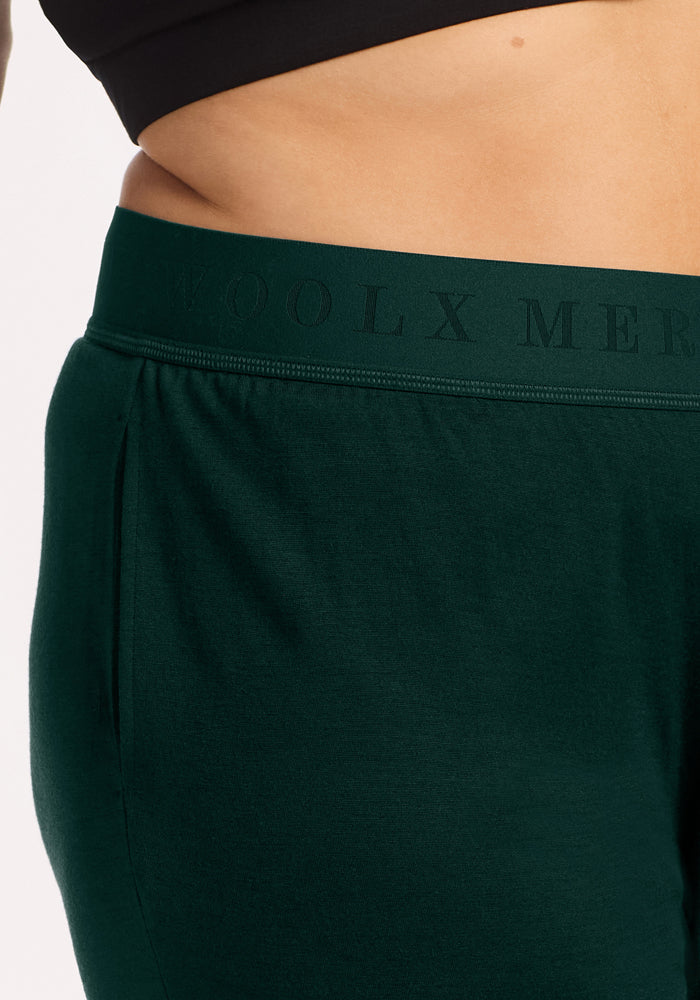 Dark green Woolx Maya Lounge Pants - Deep Pine with an elastic waistband featuring text branding.