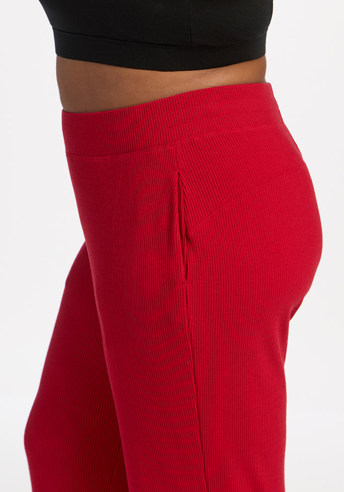 Model in Woolx Luca Ribbed Pants - Maraschino Cherry, side view with black top on white background.