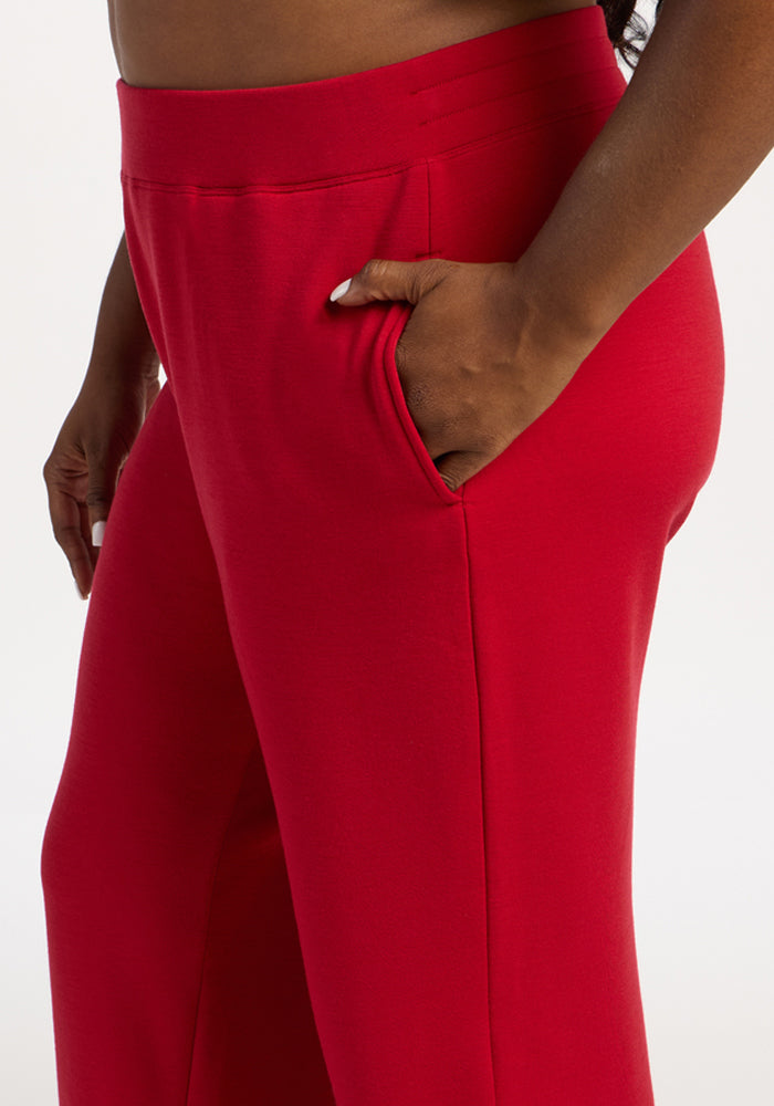 Model in Woolx Bree Lounge Pants in Maraschino Cherry, relaxed fit, right hand in pocket, waist to mid-thigh.